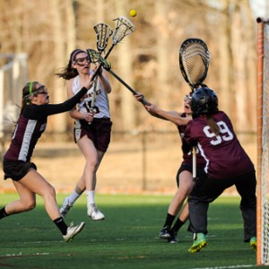 Algonquin Regional High School's Julia Insani (#15, center) gets the first score against Groton-Dunstable Regional High School's Michelle Herlihy (#3, left), Fiona Henry (#13, right rear) and Maria Antonellis (goalie).