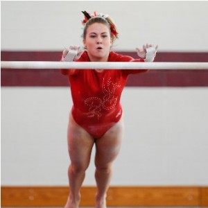 Hudson High School's Alison Tobin reaches for the bar during her performance.  Tobin scored 8.0 in the event.