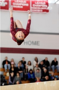 Westborough High School's Alex Romano is looking for her landing spot as she executes a reverse flip on the beam.  Romano scored a 9.8 to pace her team.