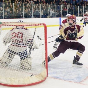 Algonquin Regional High School's Brian Ward (#7, right) scores one of his four goals against Westborough High School's Jared Ward (GK).  The puck is  at the bottom right of the net.