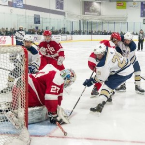 Shrewsbury High School's David Belbin (#25, right) tries to dig out the puck that St. John's High School goalkeeper Mario Pizzeri has covered up.