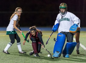 Algonquin Regional High School's Taylor Long (#17, center), stretches for the ball as Nashoba Regional High School's Katie Crowley (GK) and Sidney Lower (#7, left) defend.