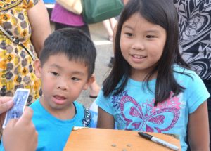The Wong siblings – Jacob, 5, and Kylie, 8 – are amazed by a card trick performed by magician Steve Charette.