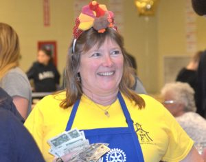 Rotarian Lynn Reynolds sells Turkey Trot raffle tickets. Photos/Ed Karvoski Jr.