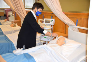 Assabet instructor Kathy Regan demonstrates working with a mannequin in one of the new high-tech hospital units.