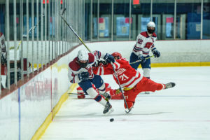 Hudson’s’ #21 Nick DiPersio and Rangers’ #4 Chris Pascale battle for possession along the boards.