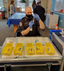 Paramedic/Firefighter Patrick McManus allots the correct amount of vaccine into syringes before they are distributed to each vaccination station. 