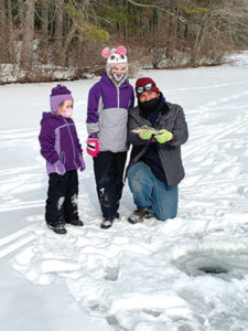 Eric Vray of Worcester, with his daughters, Emma and Olivia, show off their catch at the learn to ice fish event Cook’s Pond in Worcester.
