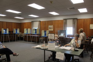 Election workers sit behind registration booths on voting day, May 4, 2021.