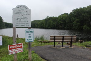 A health advisory stood in front of Dean Park Pond as of July 13.
