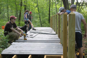 Volunteers work on a boardwalk during a weekend working session for the new Gilmore Pond accessible trail project. Photo/Ellen Bishop