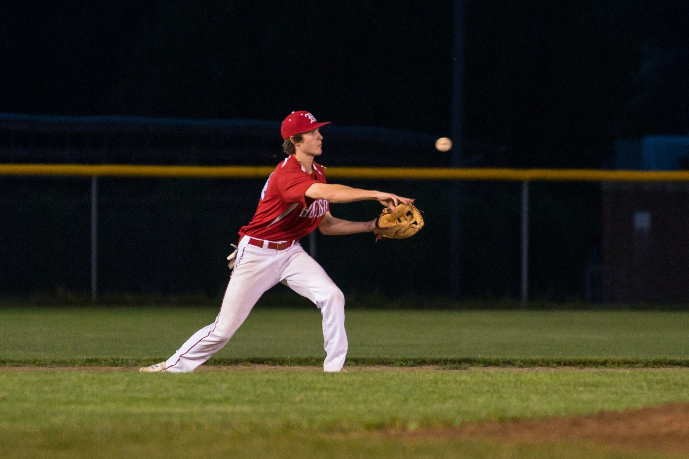 A Hudson infielder throws to a teammate late in their game against Natick.