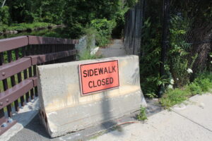 Barricades keep pedestrians away from a footpath between Mason and Houghton Streets that had washed away in 2019 causing it to cave in and fall into the Assabet River. The town is looking to repair it and reopen the trail to foot traffic. 