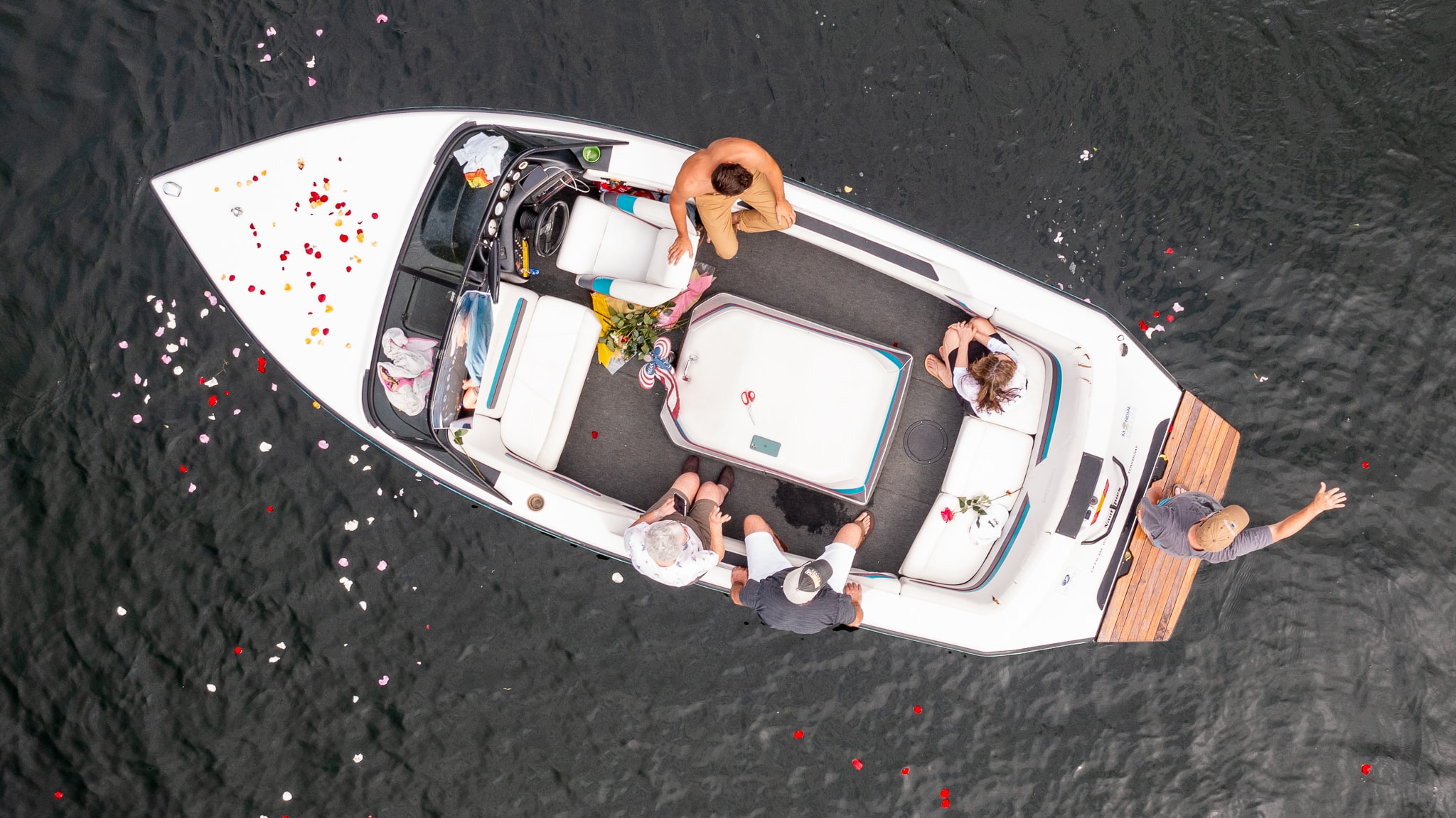 Friends and family of the late Larry Grella scattered rose petals across the water of the Ft. Meadow Reservoir at the end of a boat parade in his memory, Aug. 8.