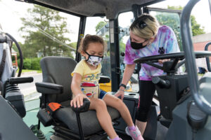 A child explores the cab of a Marlborough DPW vehicle during a ‘touch-a-truck’ event, July 29.  (Photo/Jesse Kucewicz)