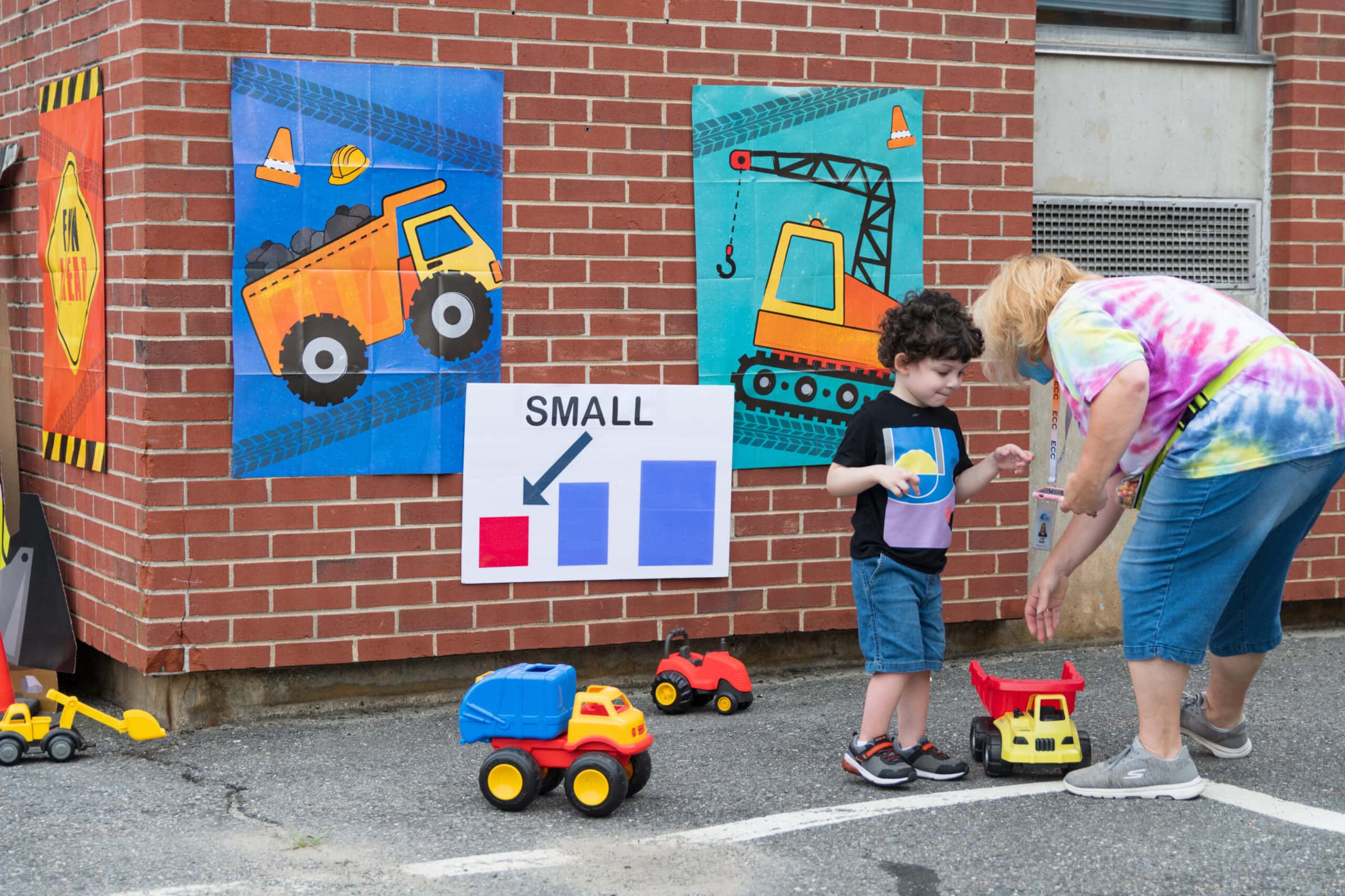 A July 29 ‘touch-a-truck’ event at the Early Childhood Center in Marlborough aimed to teach children about differences in scale, contrasting small toy trucks with actual vehicles from the city’s DPW. (Photo/Jesse Kucewicz)