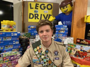 Scout Thomas Rabideau with sits with a display of Lego donations.