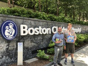 Boston Children Hospital contact Chris Ryan stands with Scout Thomas Rabideau on Longwood Avenue in Boston accepting the Lego donations.