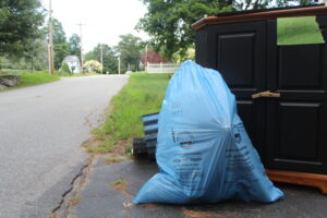  A blue, pay-as-you-throw trash bag sits at the end of a driveway on Brook Street in Shrewsbury. The town has recently faced a shortage of the trash bags.   Photo/Laura Hayes