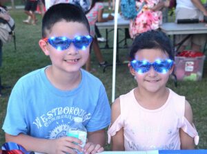 Ethan and Julia – get souvenir sunglasses from the Westborough July 4th Block Party Planning Committee in 2018.