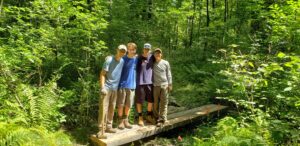 Volunteers help Westborough Boy Scout Michael O’Keefe build a series of bridges over habitually muddy portions of the Libbey Trail in town. 