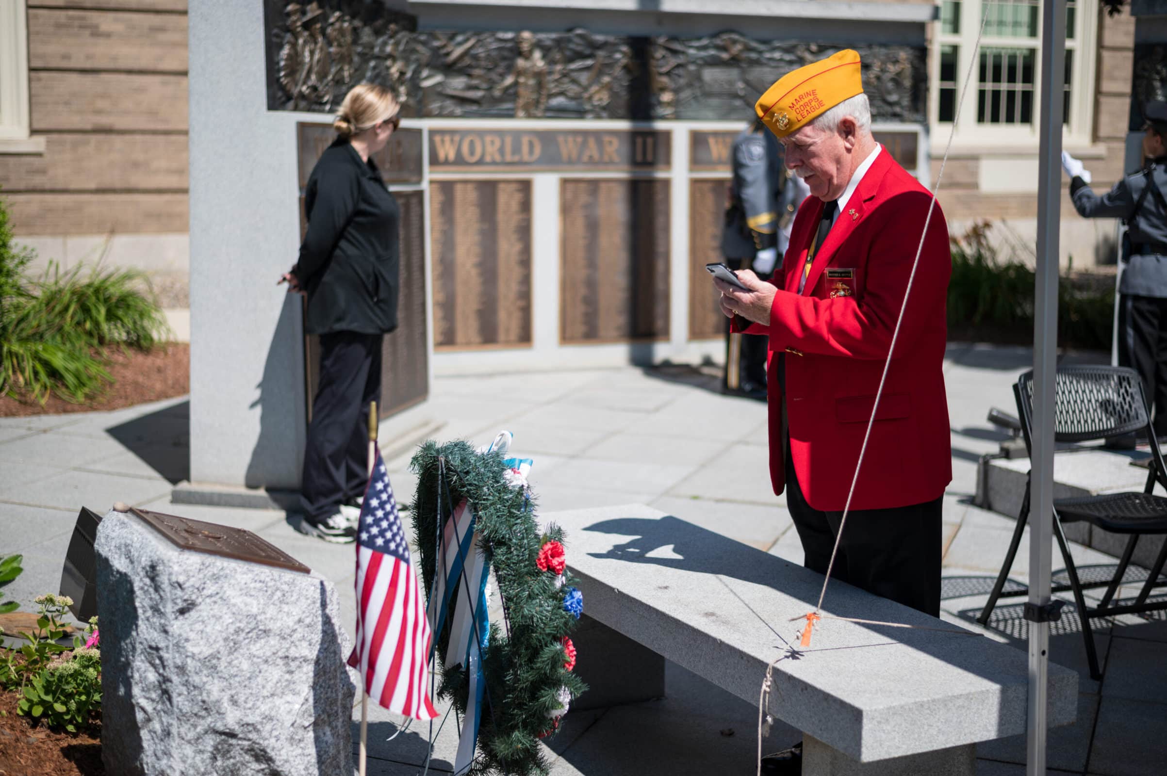 Warren Griffin, Junior Vice-Commandant of the Marine Corps League, takes a picture of the plaque and pedestal that now honor Michael Haskell outside Westborough’s Forbes Municipal Building. (Photo/Jesse Kucewicz)