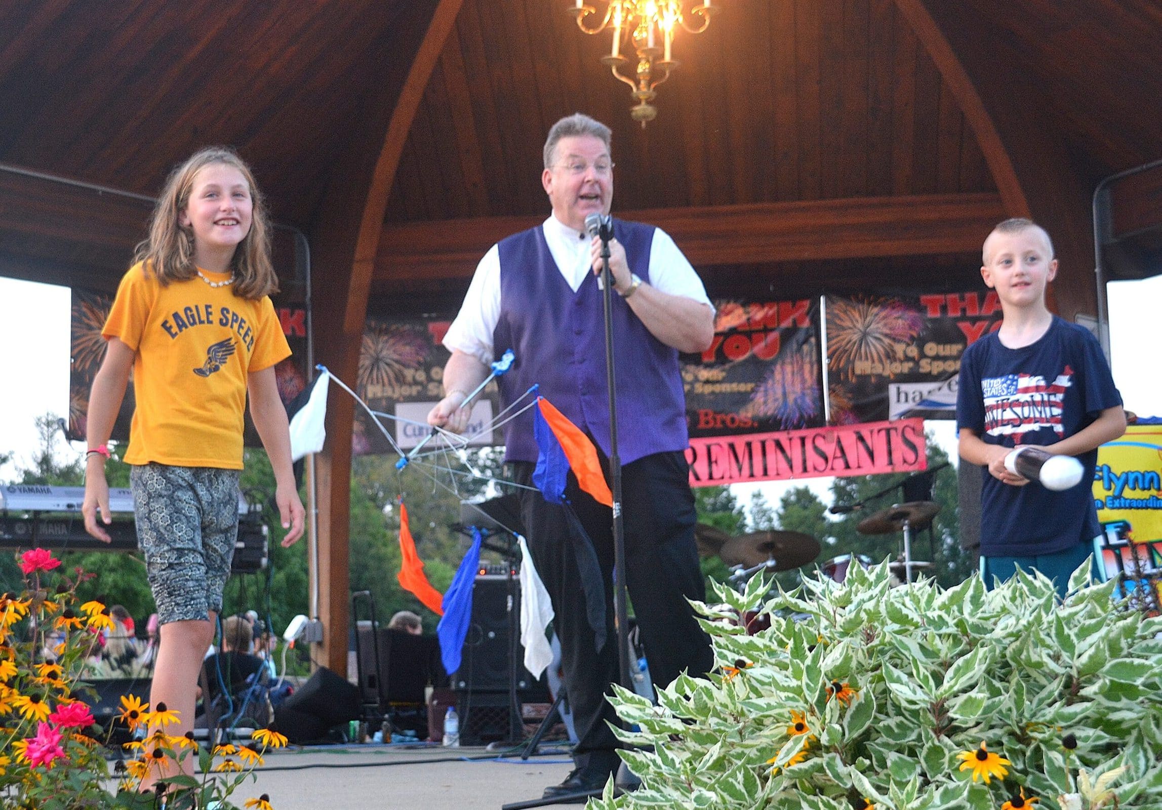 Fran Flynn (center) performs his magic show with volunteer assistants (l to r) Charlotte Erickson, 10, and Jack Steakus, 7.