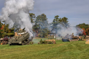  Smoke rises into the air during a past running of the Battle for the Airfield reenactment by the Collings Foundation and the American Heritage Museum.