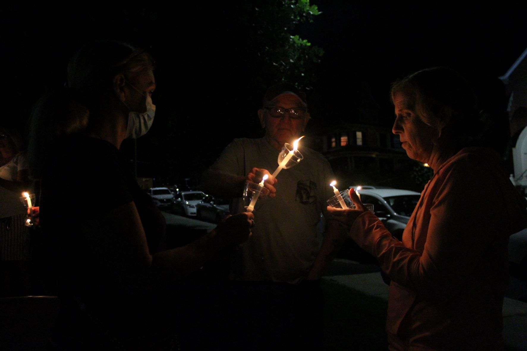 People hold candles in front of the Walker Building. (Laura Hayes)