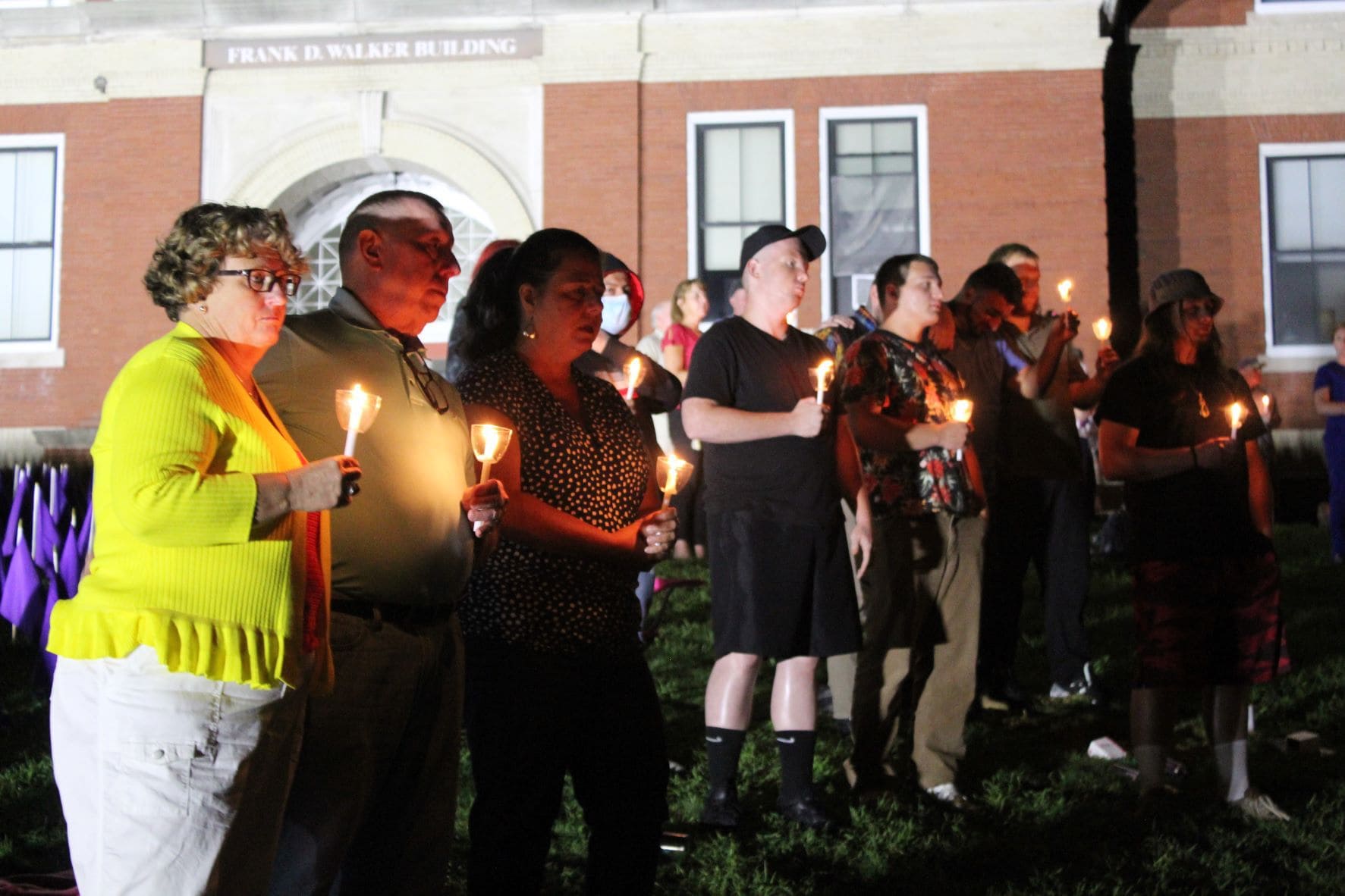 People hold candles in front of the Walker Building. (Laura Hayes)
