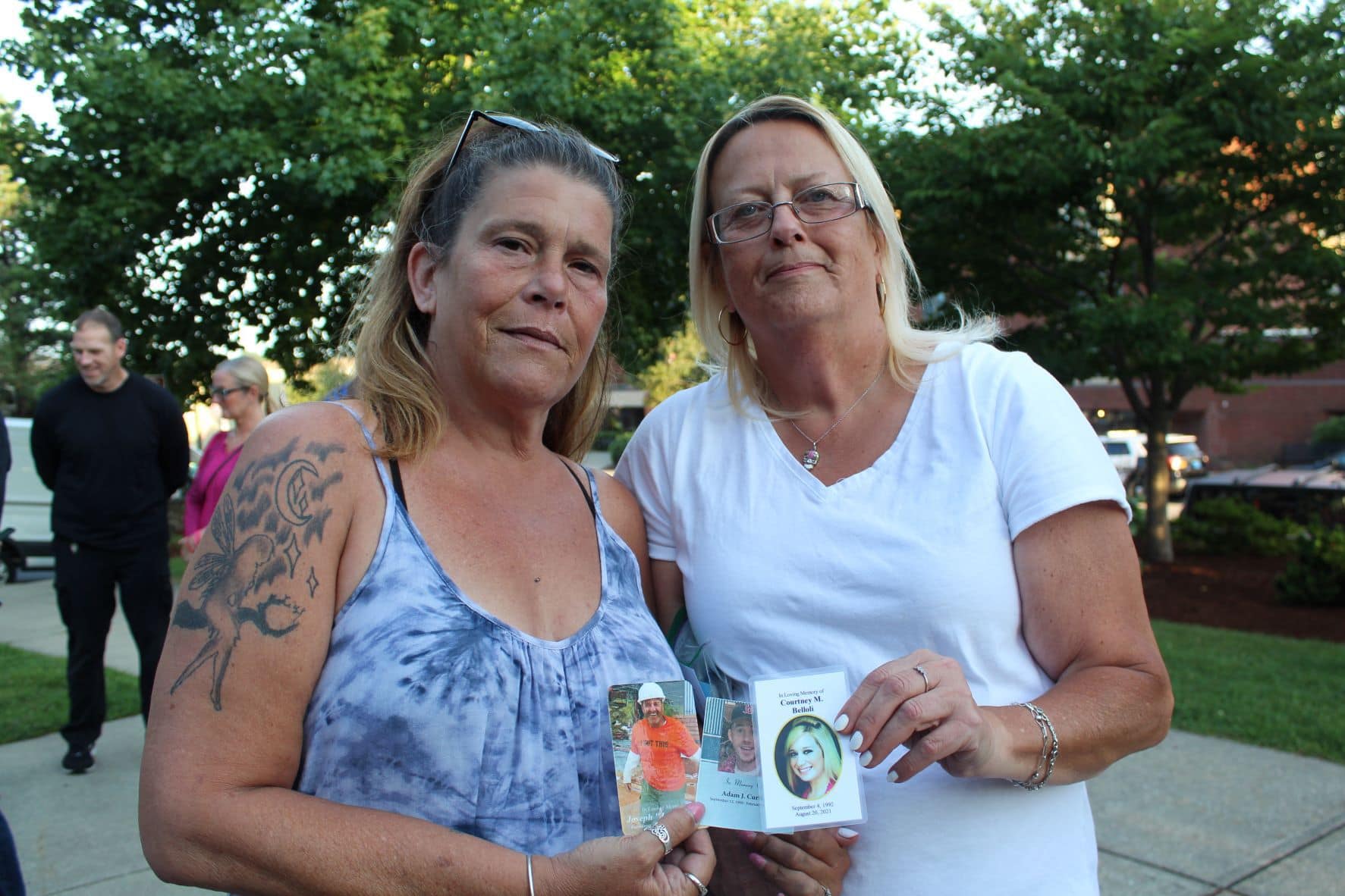 Tracy Pruett and Helen Hollis, of the Recovery Connection, hold photos of Courtney M. Belloli, Adam Curtis and Joseph Roy.