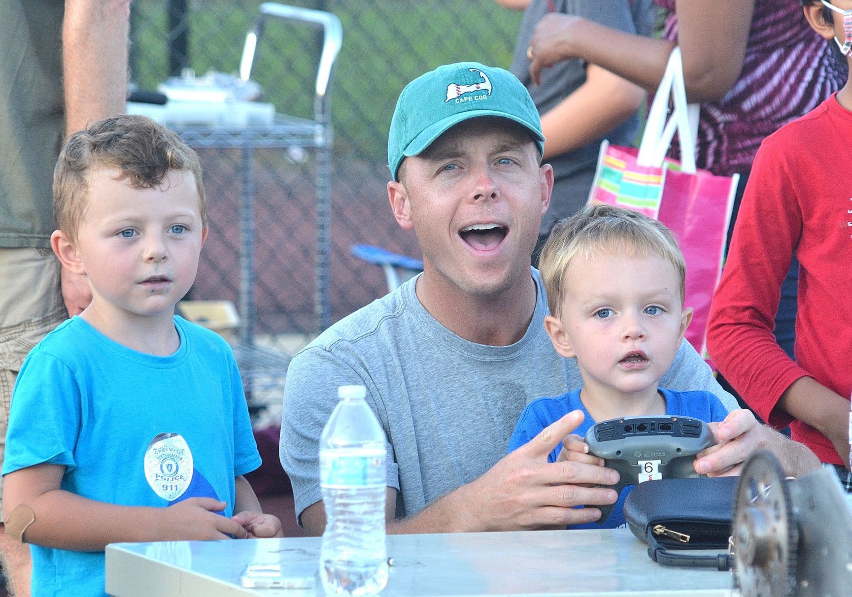 Brian Granger (center) shows his sons (l to r) Brady, 5, and Bennett, 3, how to hit a target with a Frisbee at an interactive robotics demo provided by Algonquin’s Robotics Team.