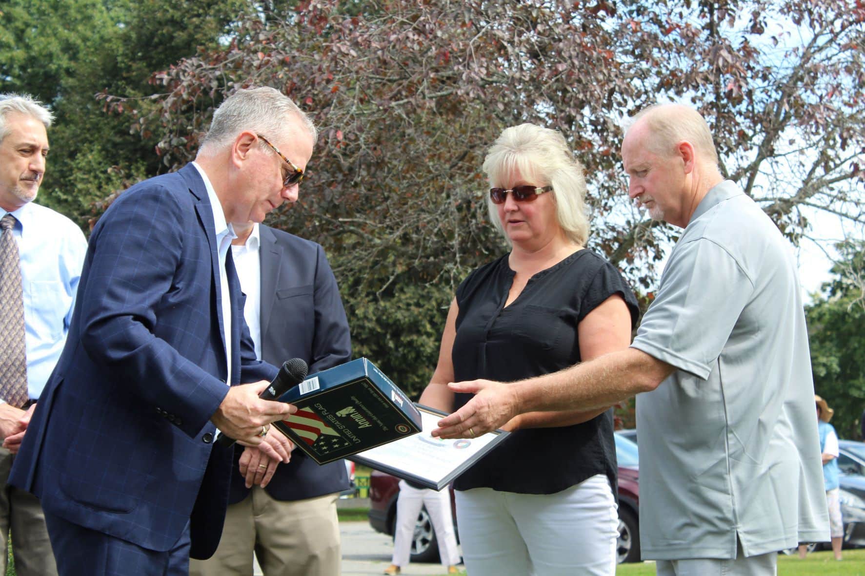 Former State Representative Harold Naughton presents a flag to Leslie and Dan Arsenault. Photos/Laura Hayes