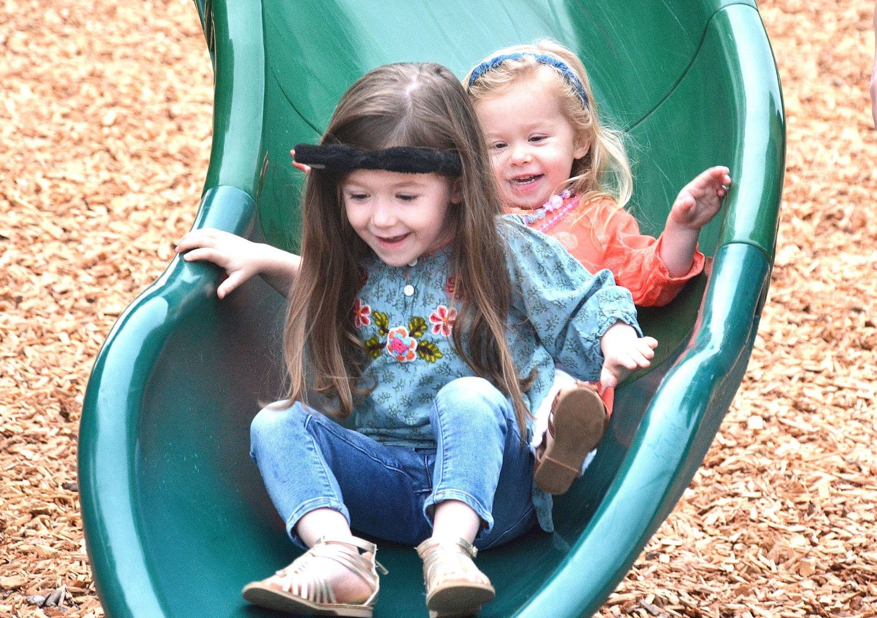 The Black sisters – Kiley, 4, and Maeve, 2 – glide to the end of the slide.