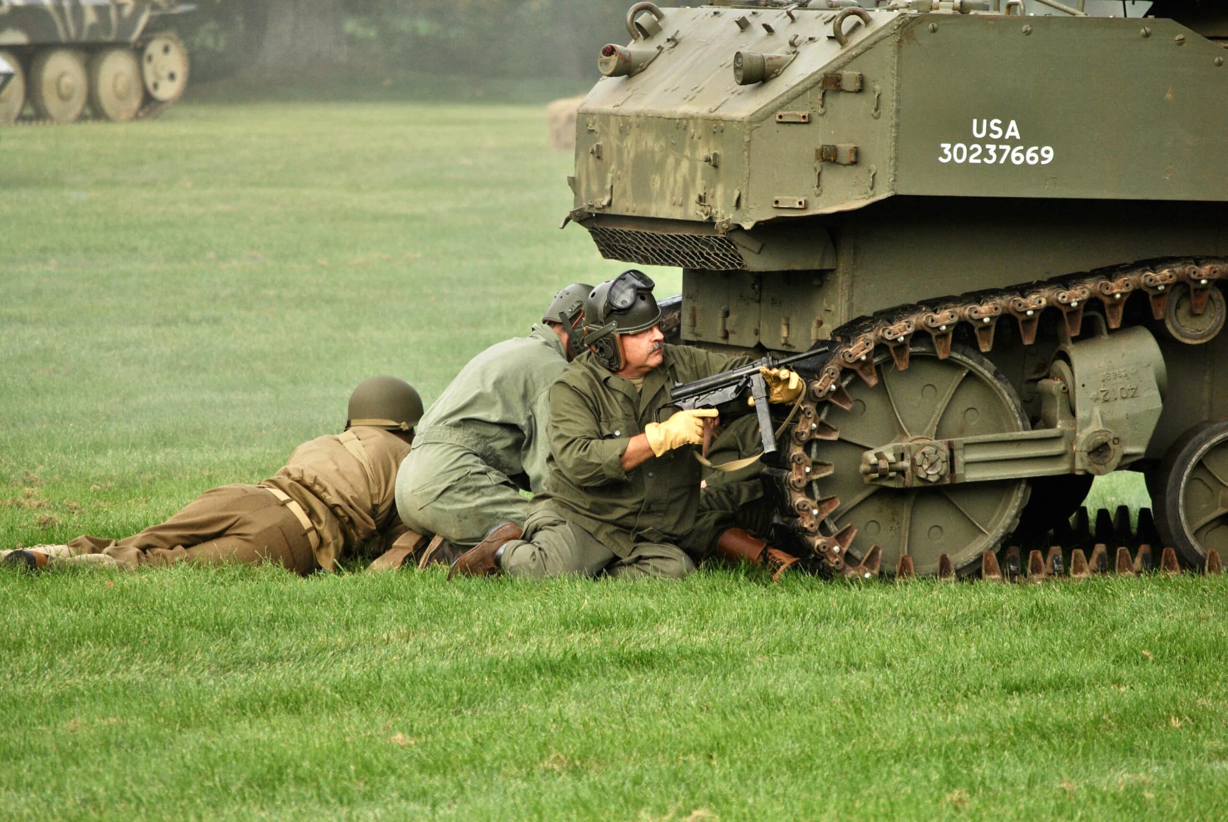 Reenactors line up behind the tracks of their tank during the early stages of this year’s Battle for the Airfield World War II reenactment.