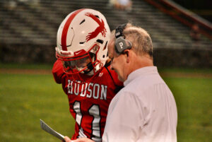 Hudson Hawks football coach Dan McAnespie speaks with quarterback Jake Attaway during a game earlier this year. 