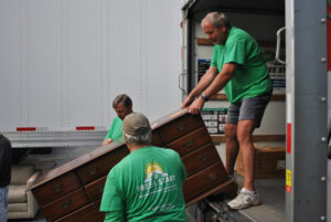 Fresh Start Furniture Bank volunteers load furniture into a waiting U-Haul truck. Volunteers coordinate supplies to be sent to refugee families resettling in the US. (Photo/Dakota Antelman)