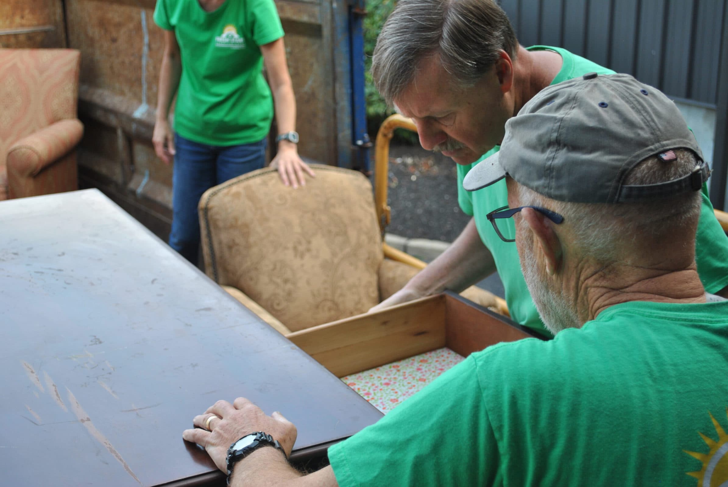 Fresh Start volunteers examine a piece of donated furniture.