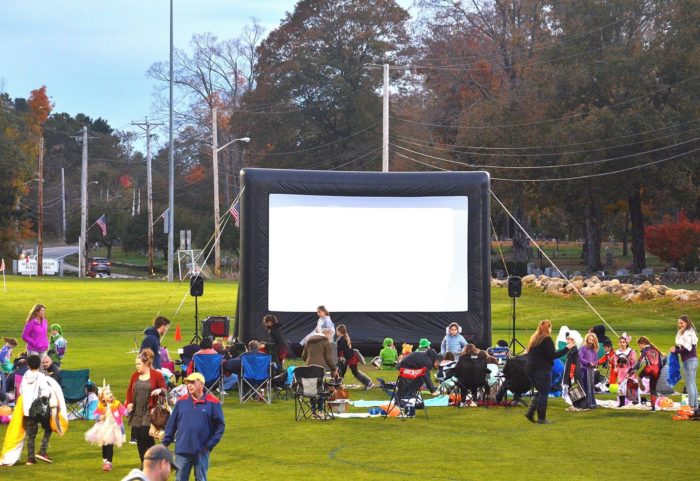 Nearing dusk, trunk-or-treaters await the outdoor screening of the animated comedy film “Monsters, Inc.” on the lawn of Woodward School. (Photo/Ed Karvoski Jr.)