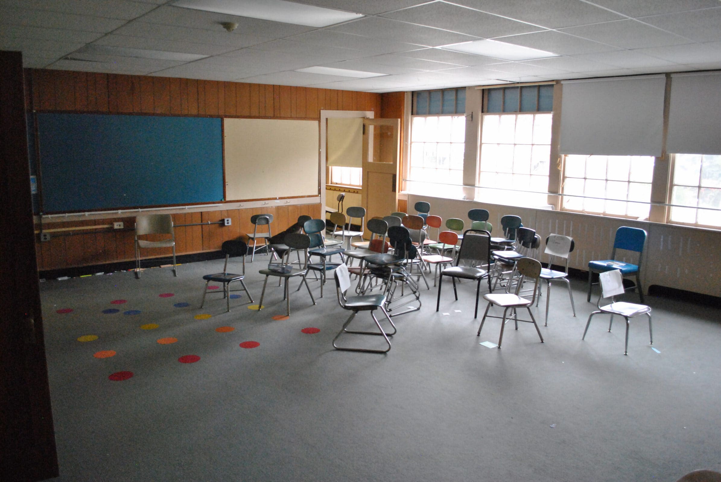 Chairs sit clustered in an otherwise empty classroom.