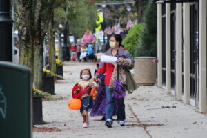A trick-or-treater walks downtown.