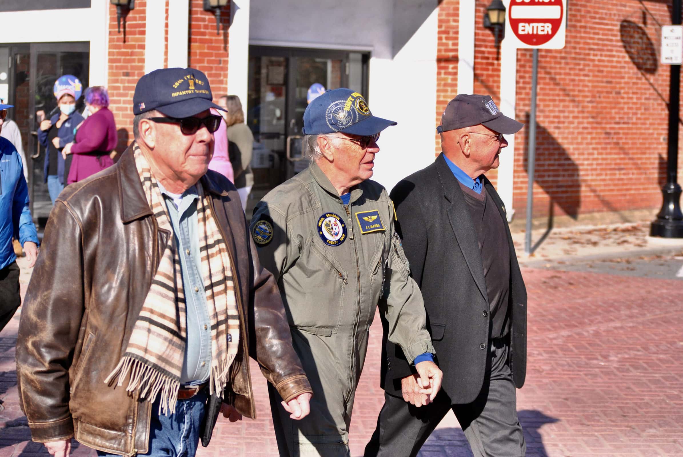 Three veterans walking in a parade.