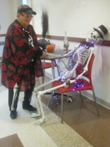  Peg Bouvier, dressed in a skeleton costume, moves to the beat of the “Flashback” band by “dancing” with “Fred,” a skeleton mascot at the Marlborough Senior Center. It was all part of the festivities at a “Halloween Bash” held last month. Photo/Mary Wenzel