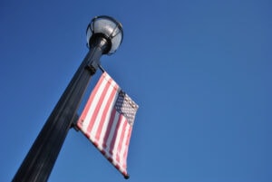 flag hanging from light pole. Blue background.