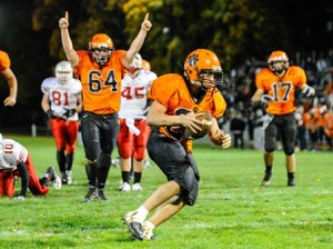 Marlborough High School's Willy Cowdrey (#25, with ball) crosses the goal line as his teammate Ryan King (#64) signals a touchdown.