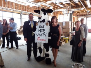 Mike Lawson, the owner-operator of the new Westborough Chick-fil-A and Karen Chapman, the president of the Corridor Nine Area Chamber of Commerce, pose for a photo with Chick-fil-A's 