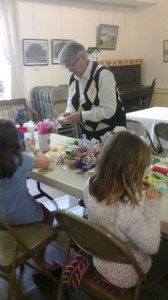 Beryl Krouse makes May baskets with visitors at the Northborough Historical Society Children's Day, May 3.