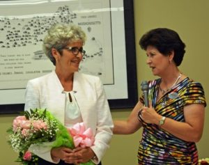 Ellen Dolan, director of the Shrewsbury Library, is presented with a bouquet of pink roses as a token of appreciation for the major role she played in bringing the expanded and renovated building project to fruition by Board of Trustees Chair Laurie Hogan.