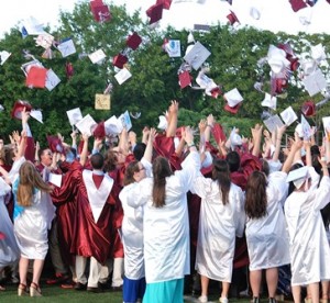 The graduates toss their caps in the air.
