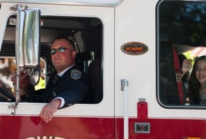 Firefighter Tim Parmenter drives the firetruck with Alyson Vincequere waving to the crowd. Parmenter has been attending the Memorial Parade in Shrewsbury since he was just a kid himself and is "honored" to be a part of it as a Shrewsbury firefighter.